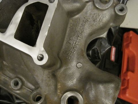 1989 Ford Bronco - A close-up view of a cast metal engine component bearing the Ford logo and a stamped part number.