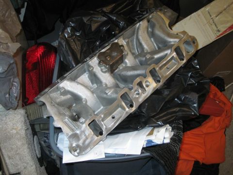 1989 Ford Bronco - An aluminum intake manifold is shown, likely for an engine build, surrounded by various items.