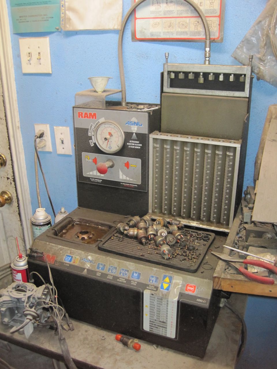 Fuel injector cleaning machine with a tray of injectors and a carburetor on the side