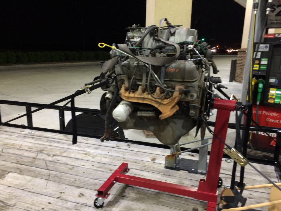 Engine on a red engine stand at a gas station at night