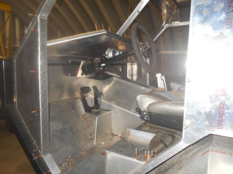 1992 Ford Bronco - The interior of a vehicle under construction shows exposed metal panels and unfinished components.