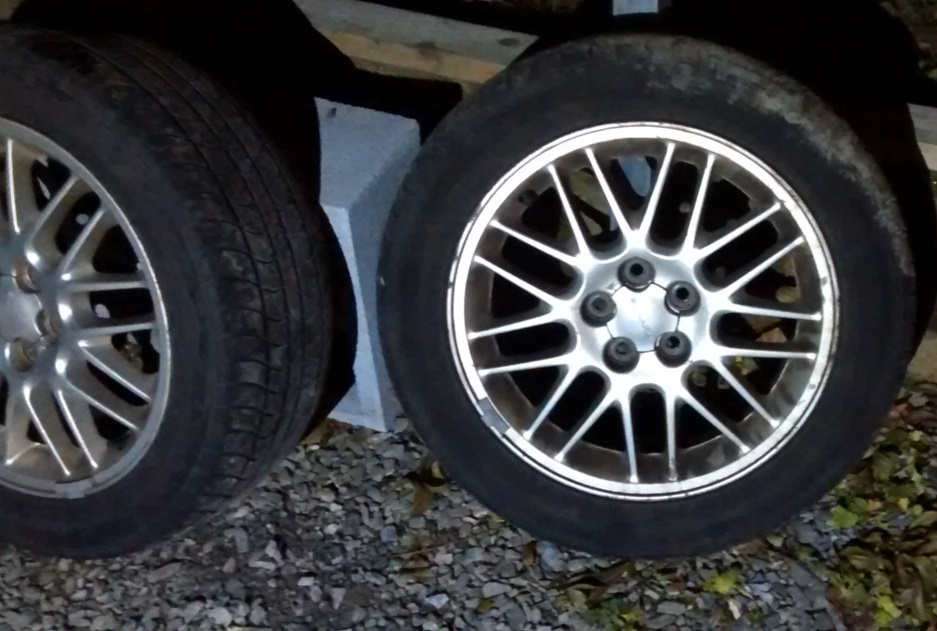 Two car wheels and tires, one with a multi-spoke alloy rim