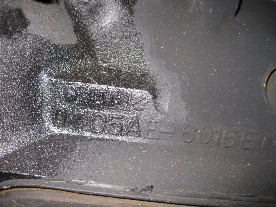 Black engine block with stamped casting numbers D6AE-6015-EA and 0105AE-6015E