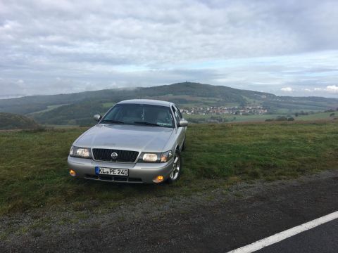 2003 Mercury Marauder - Silver 2003 Mercury Marauder sits on a grassy overlook with a village below.