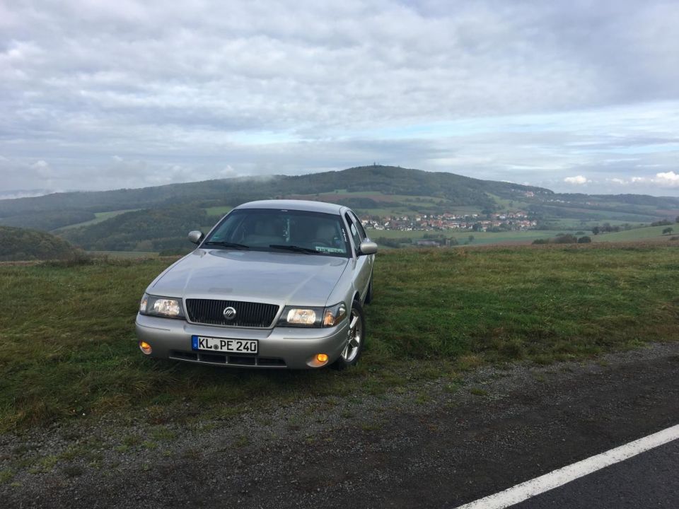 2003 Mercury Marauder parked on a hill with a town in the background