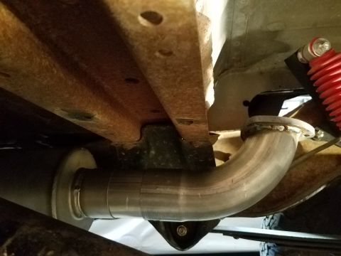 1995 Ford Bronco - The underside of a vehicle shows a newly installed exhaust system, contrasting with the rusted frame.