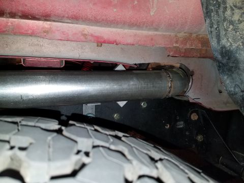 1995 Ford Bronco - Close-up view of the undercarriage of a vehicle, showing an exhaust pipe and tire.