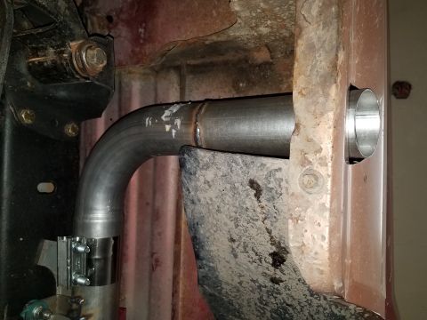 1995 Ford Bronco - A new exhaust pipe is being installed, showing a clamp and a section of the vehicle's undercarriage.