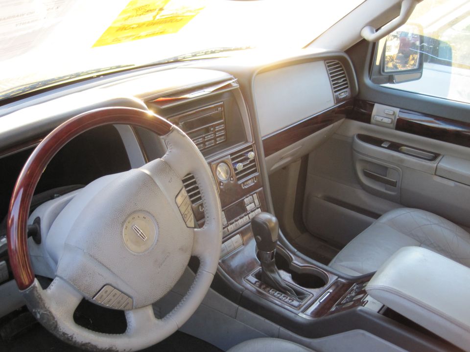 Interior of a car showing the steering wheel, dashboard, and center console with wood trim