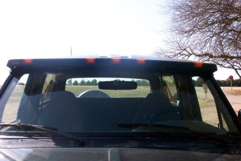 1995 Ford Bronco - The interior of a 1995 Ford Bronco is visible through the windshield, with seats and a rearview mirror.