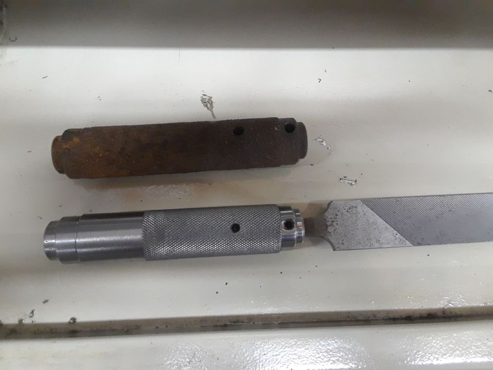 File with knurled handle and a rusty metal block with two holes