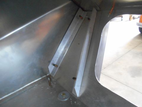 1992 Ford Bronco - The interior of a vehicle shows unfinished metal paneling and structural supports.