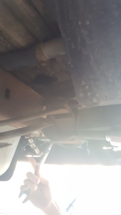 1996 Ford Bronco - A hand works on the undercarriage of a vehicle, with a Supermotors logo in the corner.
