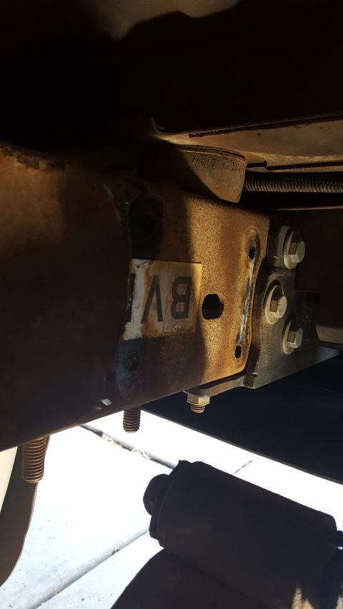 1996 Ford Bronco - Vehicle frame part with a sticker and mounting hardware visible.