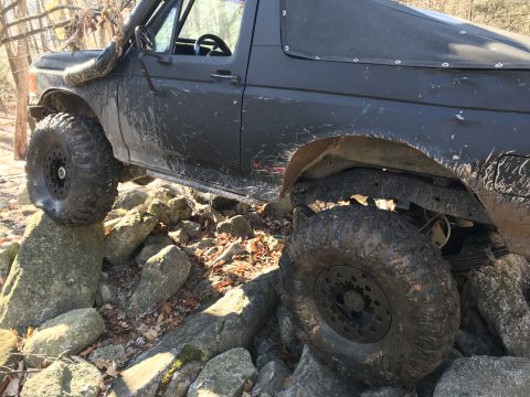 1989 Ford Bronco - This modified SUV navigates a rocky trail, its off-road capabilities.