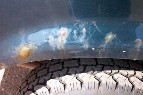 1995 Ford Bronco - Rust is forming on the lower body panel of a vehicle, just above the tire.