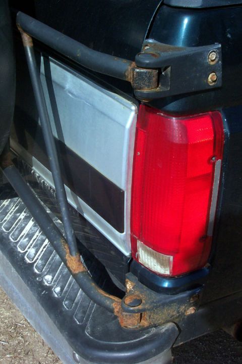 1995 Ford Bronco - The rear of a vehicle is shown, focusing on the taillight and bumper assembly with a spare tire carrier.