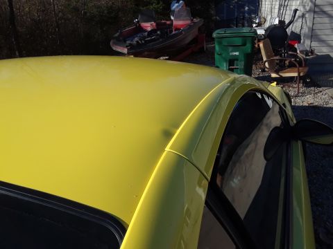 2003 Ford Mustang - A yellow car's roof and window are visible in this photo, which also includes a watermark for Supermotors.net.
