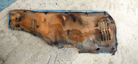 1962 MG B - A damaged insulation panel, possibly from an engine bay or firewall, shows signs of age and wear.