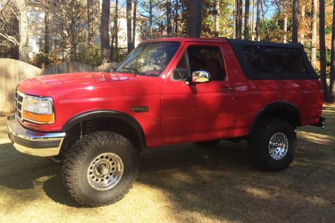 1994 Ford Bronco - This red Ford Bronco features a removable soft top and aftermarket wheels, suggesting a model year around 1992.