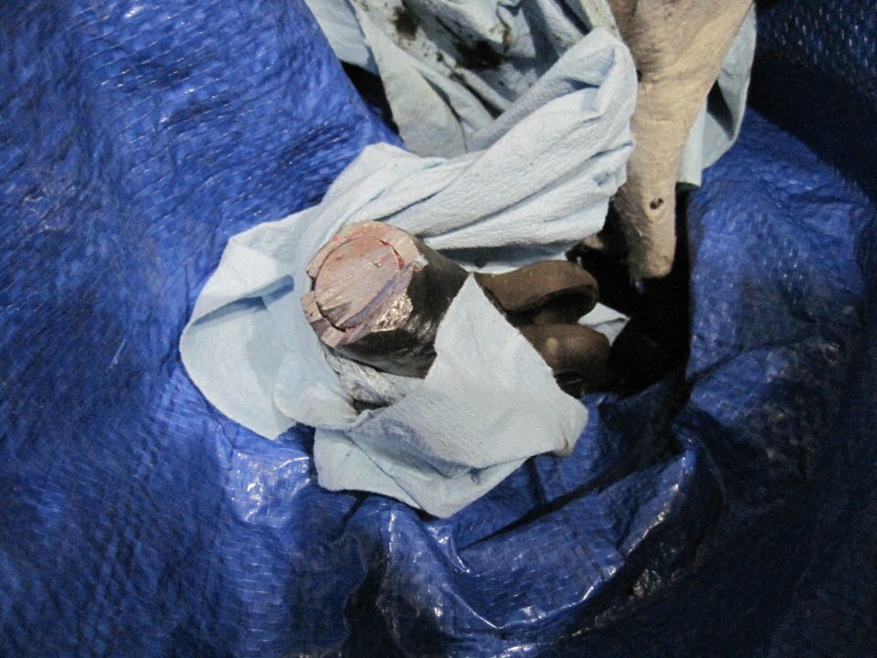 Steering box part wrapped in cloth on blue tarp