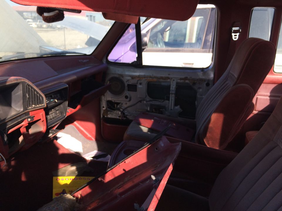 Red truck interior with missing door panel and worn seats