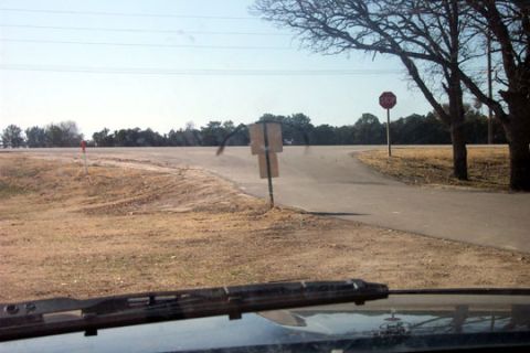 1995 Ford Bronco - View from inside a vehicle looking out at a rural road intersection with a stop sign and trees.