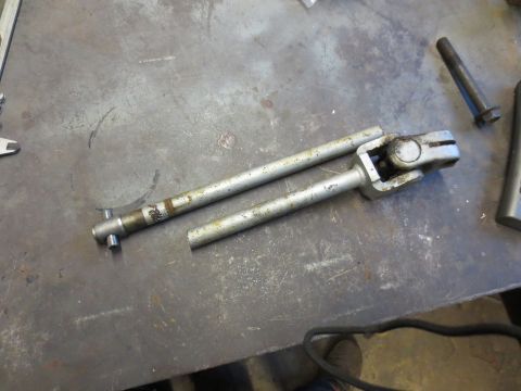 1967 Ford F-250 - A disassembled steering shaft with visible universal joints rests on a metal surface.