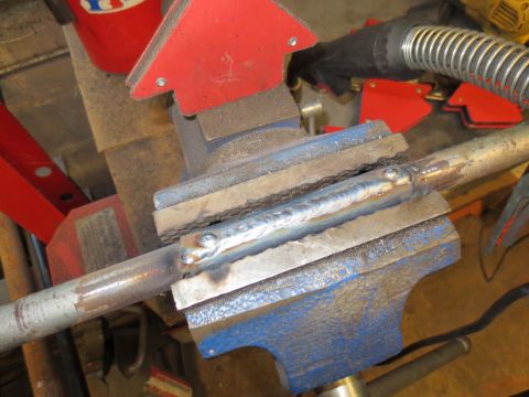 1967 Ford F-250 - A metal pipe is secured in a vise, undergoing a welding repair process.