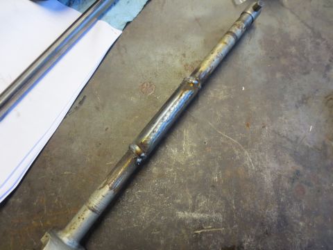 1967 Ford F-250 - A metal shaft with visible welds sits on a textured surface.