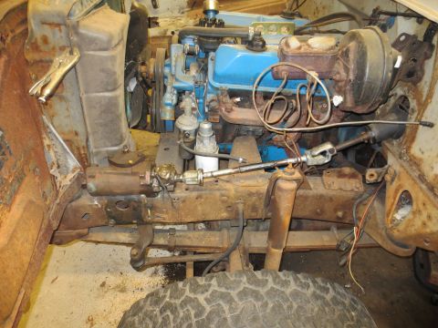 1967 Ford F-250 - Front view of a 1967 Ford F-250's engine and steering system, showing significant rust on the frame.