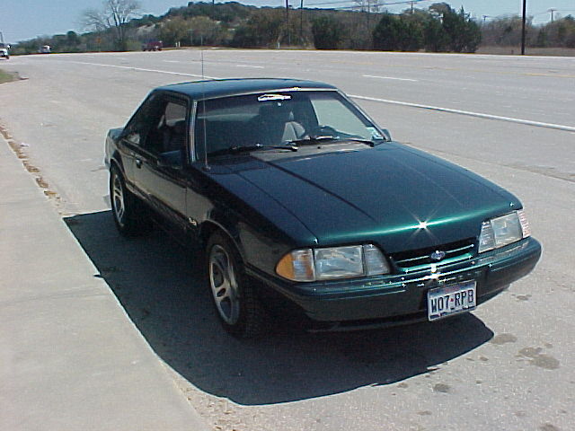 Dark green 1992 Ford Mustang coupe parked on roadside