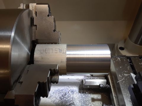 1994 Ford Bronco - A metal cylinder is being machined on a lathe, with the text 'ETMS LIGHTNING' etched into its surface.