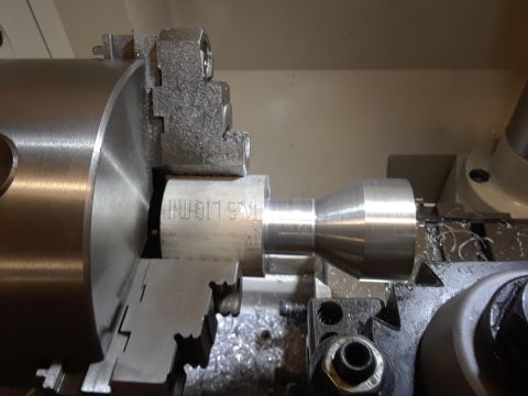 1994 Ford Bronco - A metal part is being machined on a lathe, with visible text on the workpiece.