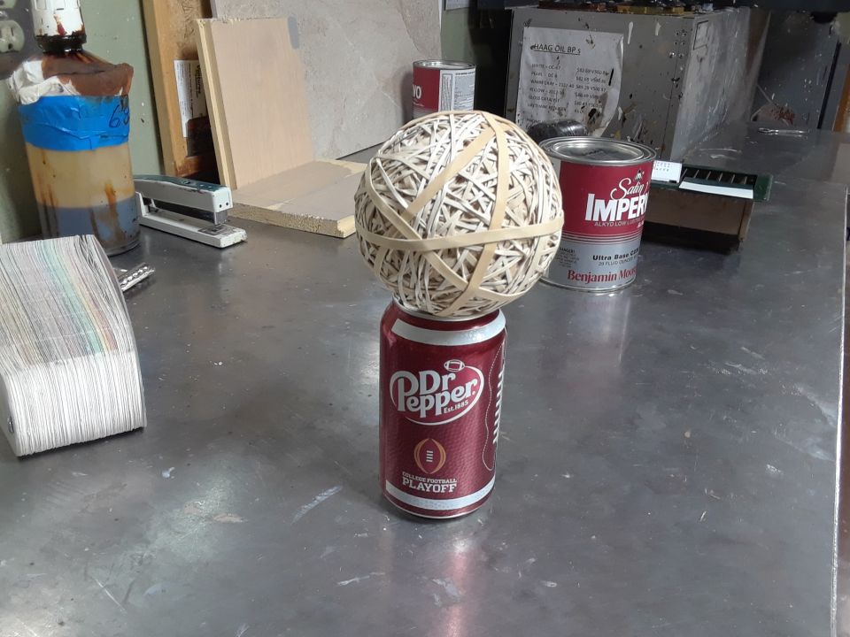 Rubber band ball balanced on a Dr. Pepper can