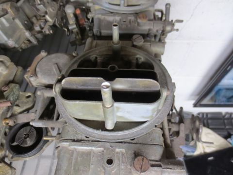 1967 Ford F-250 - A detailed view of a carburetor, showing its internal components and external mechanical parts.