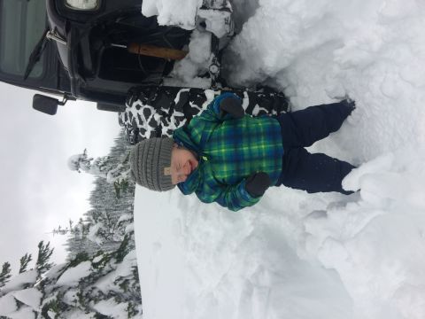 1995 Jeep Wrangler - A child enjoys the snow next to a vehicle stuck in a snowdrift.