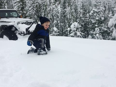 1995 Jeep Wrangler - Child plays in the snow next to a Jeep YJ that appears stuck.
