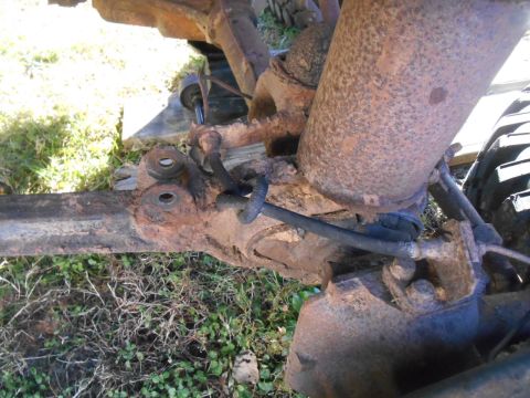 1966 Ford Bronco - Close-up view of heavily rusted suspension and brake components on an old vehicle.
