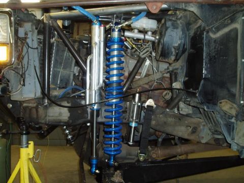 1994 Ford Bronco - Custom off-road suspension components, including blue coilover shocks and suspension linkages.