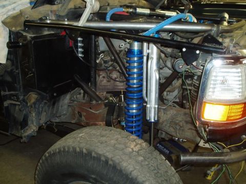 1994 Ford Bronco - This heavily modified vehicle features custom suspension components and an exposed engine bay.