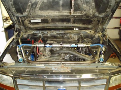 1994 Ford Bronco - Aftermarket suspension components, including Fox shocks and a custom roll cage, are visible in the engine bay.