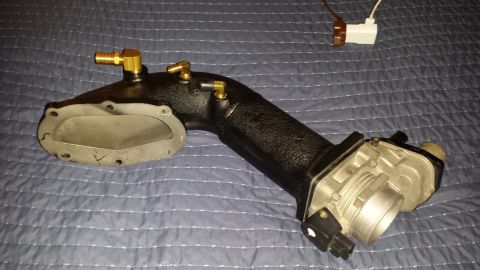2005 Mercury Grand Marquis - An automotive intake manifold with a throttle body is shown against a textured blue background.