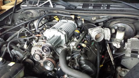 2005 Mercury Grand Marquis - Engine bay a supercharger, hoses, and belts, likely part of a performance modification.