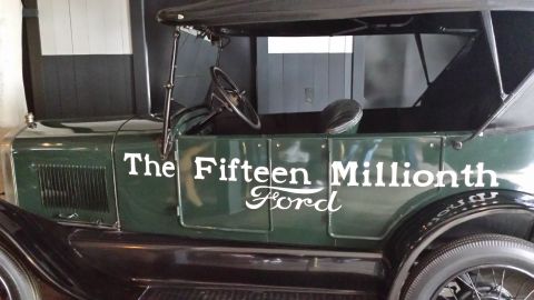 1995 Ford Bronco - A close-up side view of a dark green vintage Ford Model T with white lettering that reads "The Fifteenth Millionth Ford". The car has a bla…