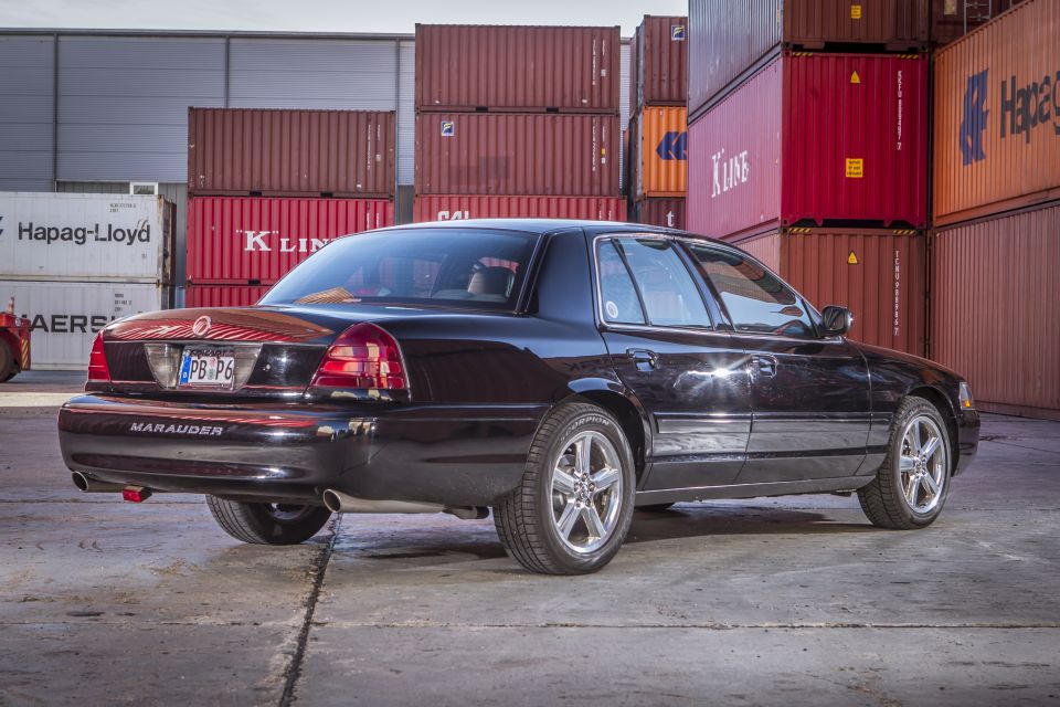 Black 2003 Mercury Marauder rear passenger side view, parked in front of shipping containers.