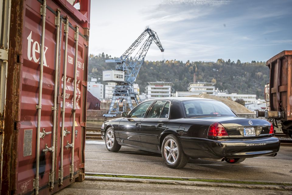 Black 2003 Mercury Marauder parked next to a red shipping container.