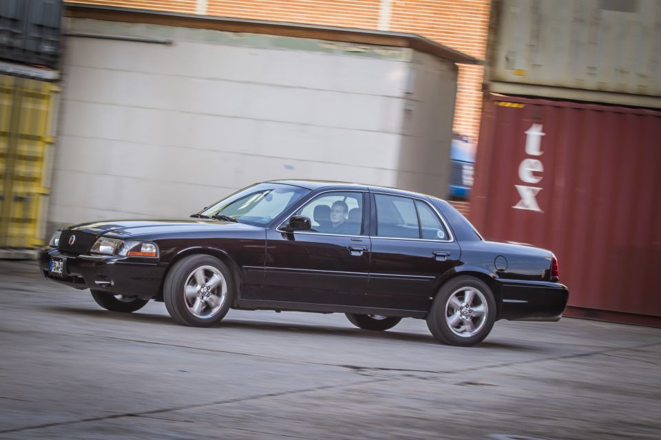 Black 2003 Mercury Marauder sedan driving on a paved surface.