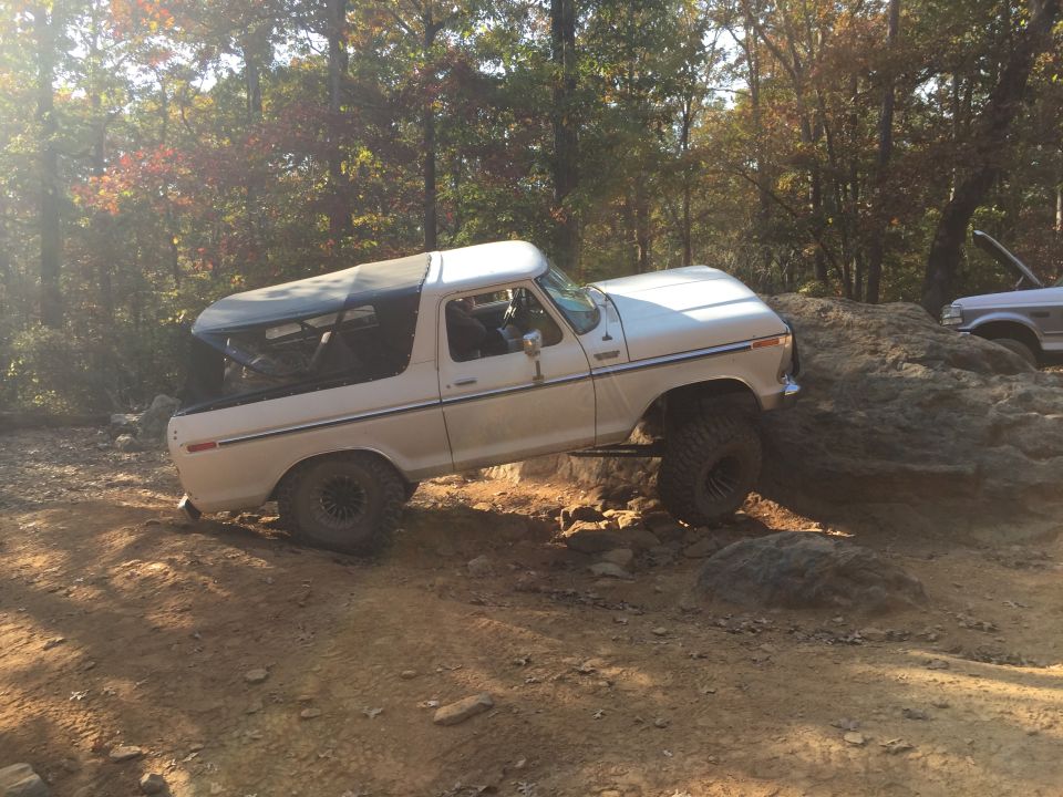 White Ford Bronco off-roading over rocks