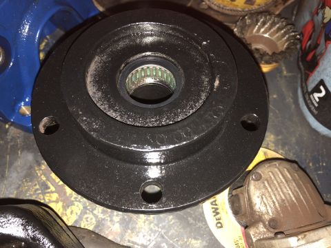 1995 Ford F-150 - A black flange with a bearing is shown in the center of the image, with a blue part of a pump visible on the left. Tools and other parts ar…